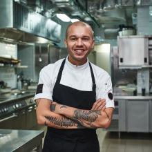 male in chef uniform standing in commercial kitchen